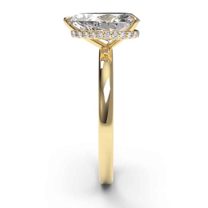 Side view of a pear cut diamond hidden halo engagement ring yellow gold