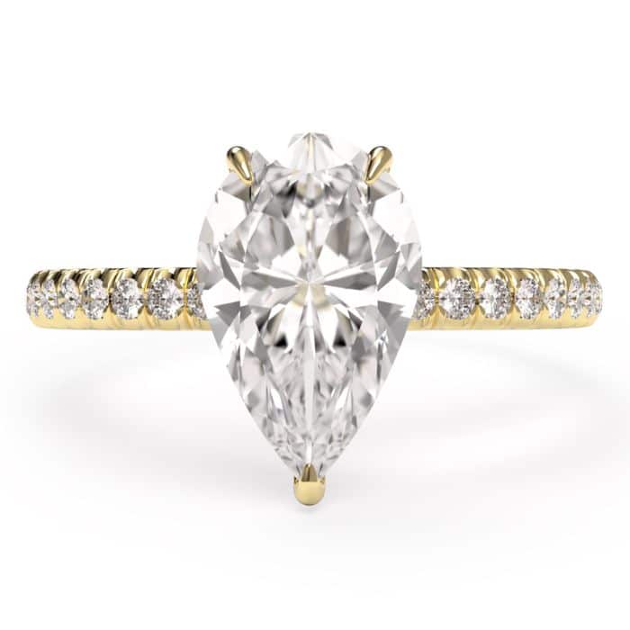 birds eye view of a pear cut diamond shoulder engagement ring in yellow gold metal