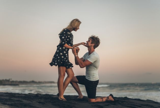 Image of a man proposing on the beach