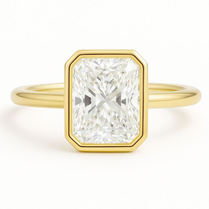 Bezel set diamond engagement ring with a radiant cut diamond in yellow gold